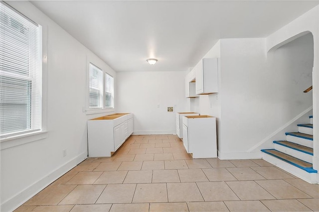 2232 Annette St, New Orleans, LA 70119 - kitchen with white cabinets and light tile patterned floors