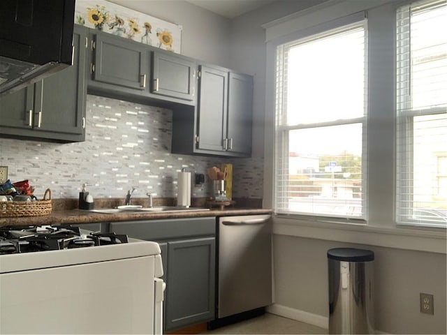 3929 Octavia St, New Orleans, LA 70125 - kitchen featuring dishwasher, gray cabinets, backsplash, and healthy amount of natural light