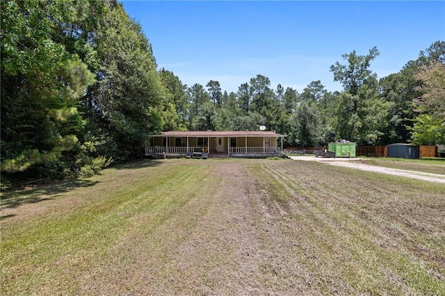 24473 Sanders Rd, Covington, LA 70435 - view of front of house with covered porch, a storage shed, a front lawn, and driveway
