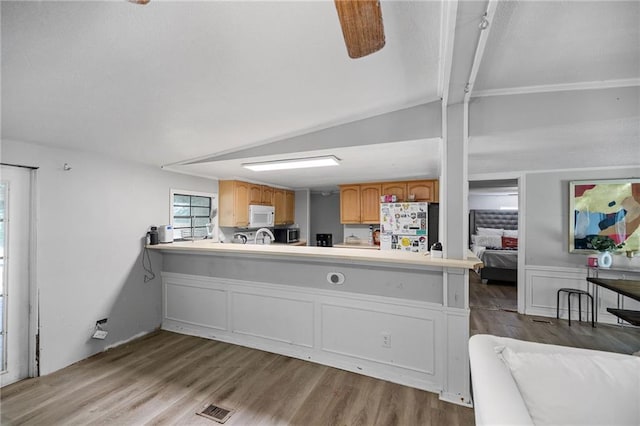 24473 Sanders Rd, Covington, LA 70435 - kitchen featuring freestanding refrigerator, white microwave, wood finished floors, light countertops, and lofted ceiling