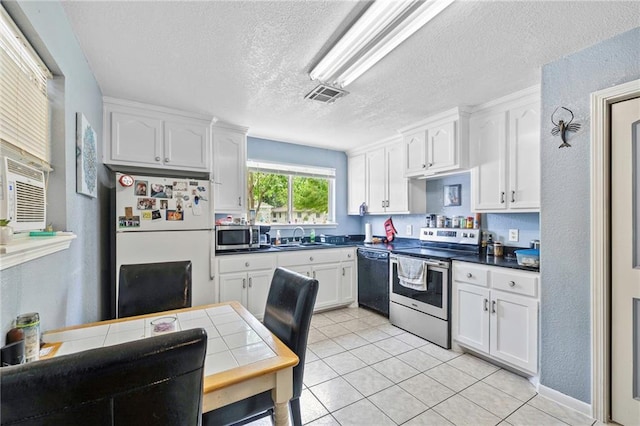 370 Cumberland Dr, Slidell, LA 70458 - kitchen featuring stainless steel appliances, a textured ceiling, white cabinets, dark countertops, and light tile patterned flooring