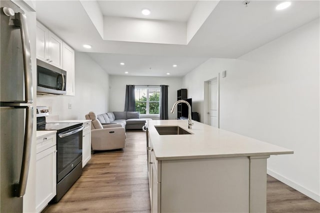 2100 Saint Thomas St Unit 202, New Orleans, LA 70130 - kitchen with stainless steel appliances, recessed lighting, light wood-style floors, white cabinetry, and open floor plan