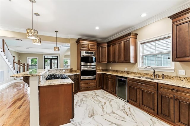 4953 Music St, New Orleans, LA 70122 - kitchen with appliances with stainless steel finishes, a kitchen bar, a peninsula, ornamental molding, and hanging light fixtures
