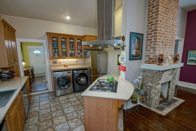 1025 General Pershing St, New Orleans, LA 70115 - kitchen featuring appliances with stainless steel finishes, island range hood, washer and clothes dryer, light countertops, and brown cabinetry