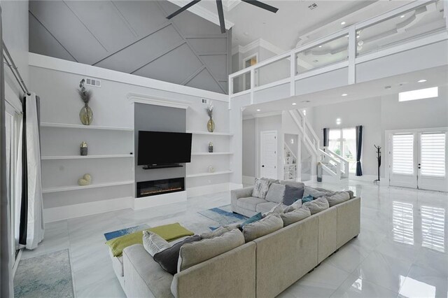 251 Oakmont Dr, New Orleans, LA 70128 - living area with a towering ceiling, built in features, a glass covered fireplace, a ceiling fan, and stairway