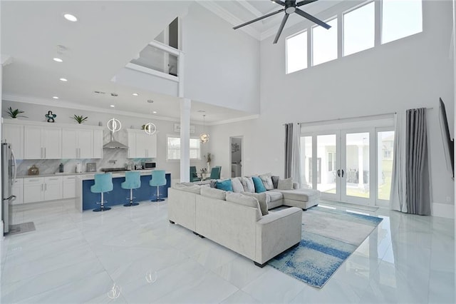 251 Oakmont Dr, New Orleans, LA 70128 - living room with ceiling fan, a towering ceiling, crown molding, light marble finish flooring, and french doors