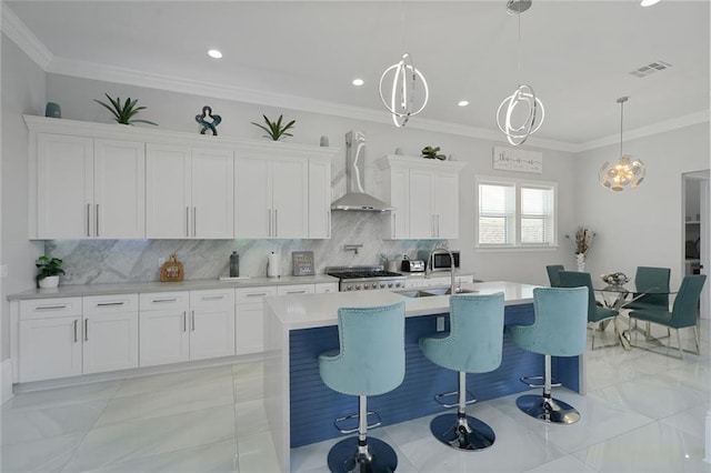 251 Oakmont Dr, New Orleans, LA 70128 - kitchen with wall chimney range hood, a center island with sink, light marble finish floors, light countertops, and white cabinets