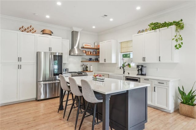 845 Pontalba St, New Orleans, LA 70124 - kitchen featuring stainless steel appliances, wall chimney range hood, a kitchen breakfast bar, white cabinetry, and recessed lighting