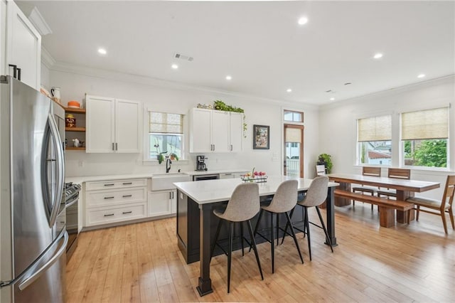 845 Pontalba St, New Orleans, LA 70124 - kitchen featuring stainless steel appliances, healthy amount of natural light, a breakfast bar area, ornamental molding, and recessed lighting