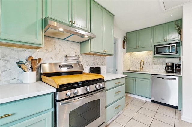 541 Gelpi Ave, Jefferson, LA 70121 - kitchen featuring appliances with stainless steel finishes, under cabinet range hood, green cabinetry, light tile patterned floors, and backsplash