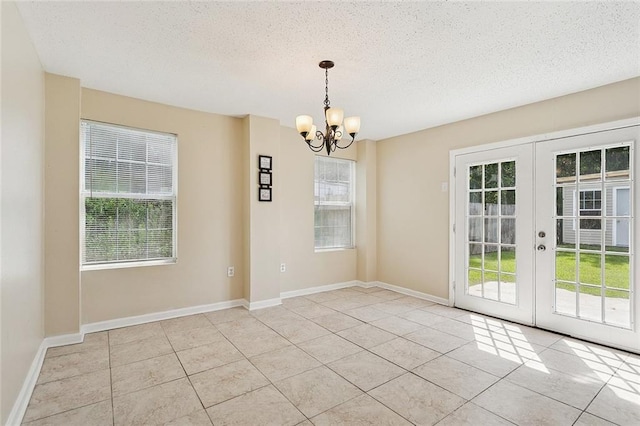 128 Marilyn Dr, Slidell, LA 70461 - unfurnished room with a chandelier, light tile patterned flooring, a textured ceiling, and french doors