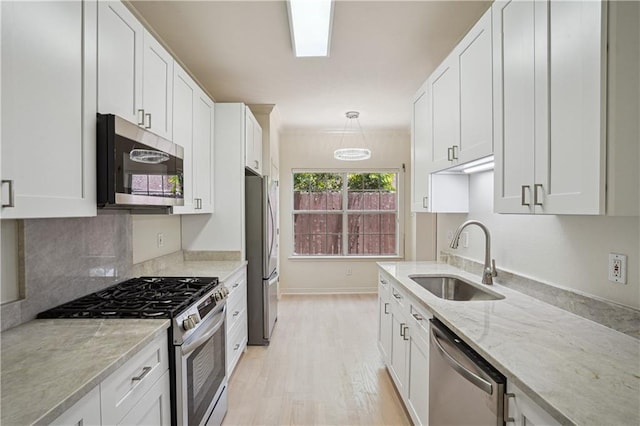 505 Rose St, Metairie, LA 70005 - kitchen featuring stainless steel appliances, light wood-type flooring, light stone countertops, and white cabinets
