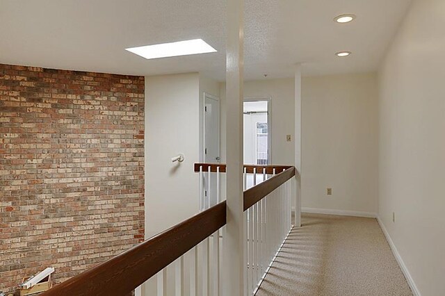 4433-35 Carondelet St, New Orleans, LA 70115 - corridor with an upstairs landing, recessed lighting, light colored carpet, brick wall, and a skylight