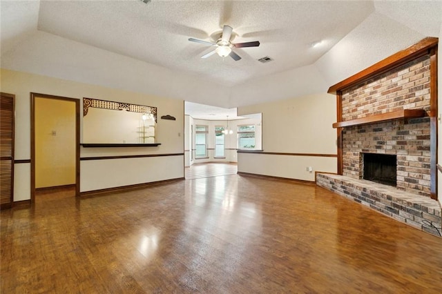 632 Brouilly Dr, Kenner, LA 70065 - unfurnished living room featuring a ceiling fan, vaulted ceiling, wood finished floors, a textured ceiling, and a brick fireplace