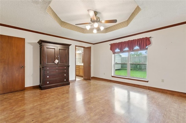 632 Brouilly Dr, Kenner, LA 70065 - empty room featuring a textured ceiling, light wood-style flooring, a ceiling fan, a tray ceiling, and ornamental molding