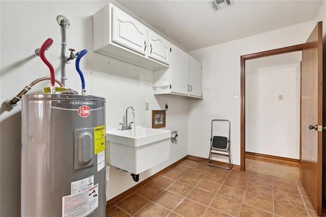 632 Brouilly Dr, Kenner, LA 70065 - laundry area featuring water heater, cabinet space, electric dryer hookup, hookup for a washing machine, and tile patterned floors