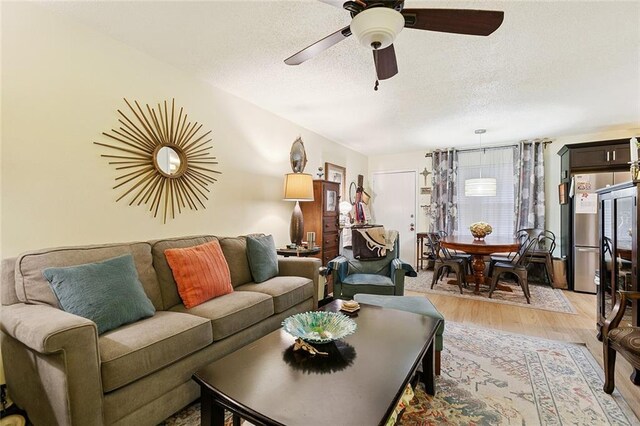 2704 Whitney Pl Unit 922, Metairie, LA 70002 - living room featuring light wood-style flooring, a textured ceiling, and a ceiling fan