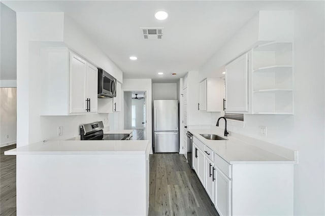 1408 N Sugar Ridge Rd, La Place, LA 70068 - kitchen with stainless steel appliances, open shelves, light wood-style flooring, a peninsula, and white cabinets