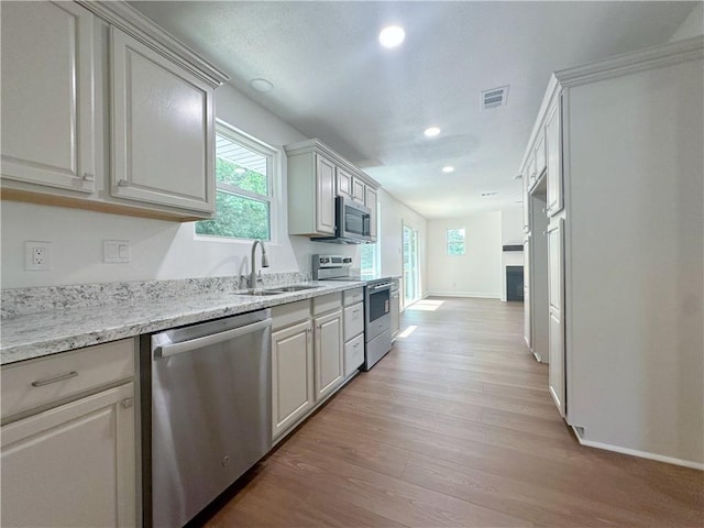 105 Kempsey Ct, Slidell, LA 70458 - kitchen featuring stainless steel appliances, light wood-style floors, healthy amount of natural light, recessed lighting, and light stone countertops