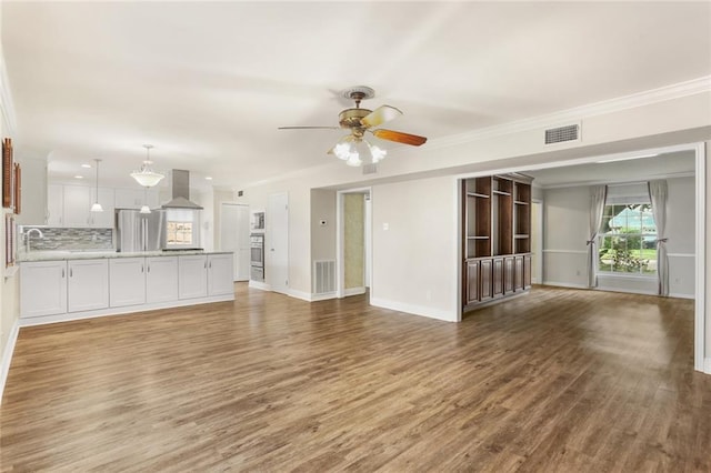 1524 Peach St, Metairie, LA 70001 - unfurnished living room with ornamental molding, light wood-style flooring, and a ceiling fan
