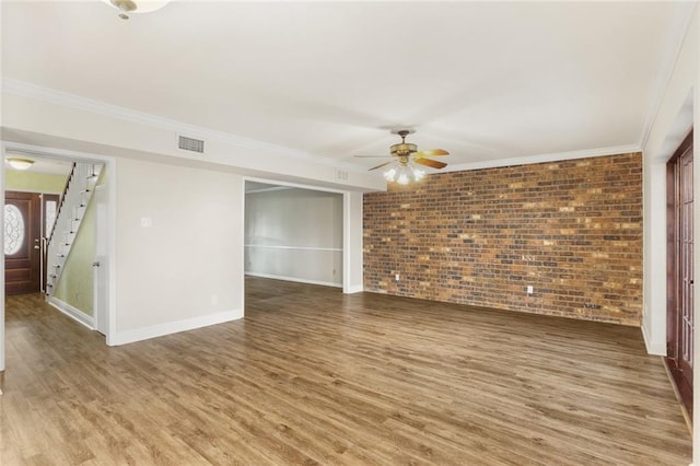 1524 Peach St, Metairie, LA 70001 - spare room with brick wall, wood finished floors, ceiling fan, stairs, and crown molding