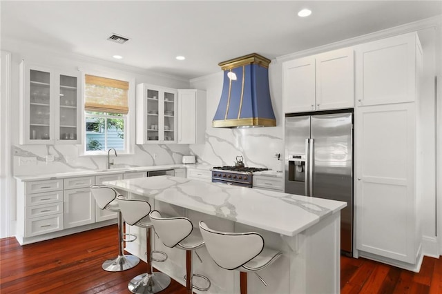 901 Henry Clay Ave, New Orleans, LA 70118 - kitchen featuring stainless steel appliances, a breakfast bar, glass insert cabinets, white cabinetry, and dark wood-style flooring