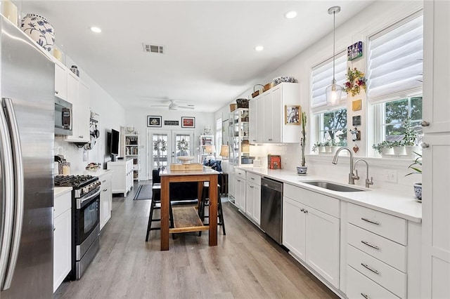 3116 Beaulieu St, Metairie, LA 70001 - kitchen with appliances with stainless steel finishes, backsplash, a ceiling fan, hanging light fixtures, and light wood-style flooring