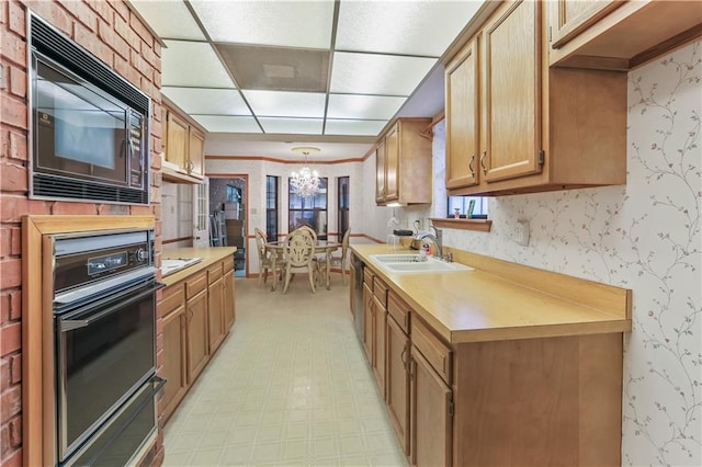 2820 Metairie Ct, Metairie, LA 70002 - kitchen with black appliances, wallpapered walls, a chandelier, light countertops, and a drop ceiling