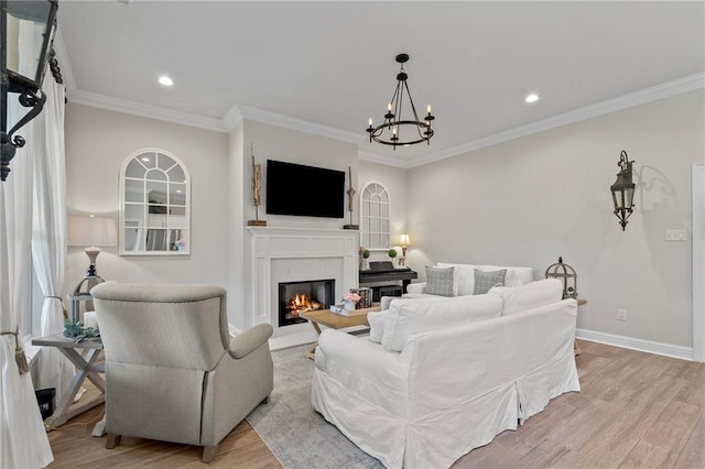 502 Terrace Lake Dr, Covington, LA 70435 - living room featuring a glass covered fireplace, light wood-style flooring, a chandelier, crown molding, and recessed lighting