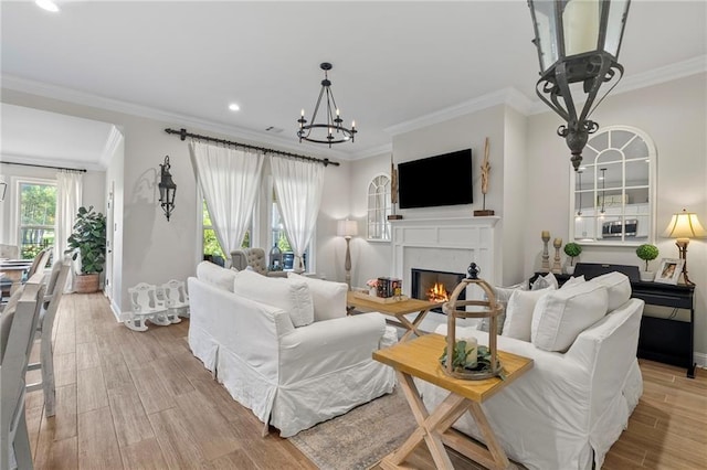 502 Terrace Lake Dr, Covington, LA 70435 - living area featuring a glass covered fireplace, crown molding, a chandelier, light wood-type flooring, and recessed lighting