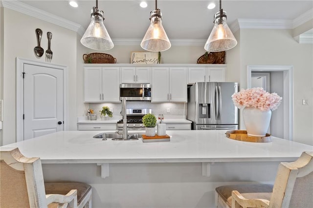 502 Terrace Lake Dr, Covington, LA 70435 - kitchen with stainless steel appliances, white cabinets, crown molding, a kitchen breakfast bar, and a spacious island