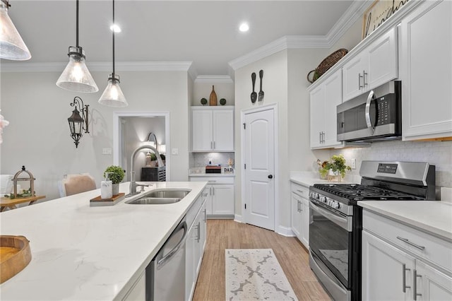 502 Terrace Lake Dr, Covington, LA 70435 - kitchen featuring appliances with stainless steel finishes, ornamental molding, tasteful backsplash, hanging light fixtures, and white cabinetry