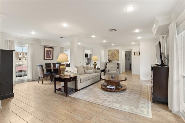 2521 Metairie Lawn Dr Unit 214, Metairie, LA 70002 - living room with ornate columns, crown molding, recessed lighting, and light wood-style flooring