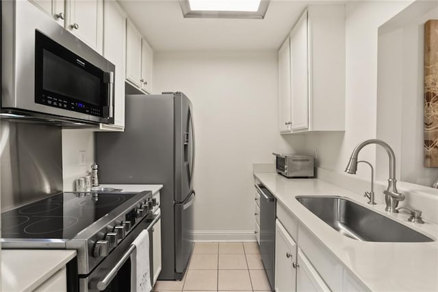 2521 Metairie Lawn Dr Unit 214, Metairie, LA 70002 - kitchen featuring stainless steel appliances, white cabinets, light countertops, and light tile patterned floors