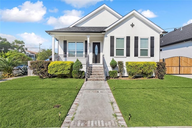 5502 Wilton Dr, New Orleans, LA 70122 - view of front facade with stucco siding, a front yard, and a gate