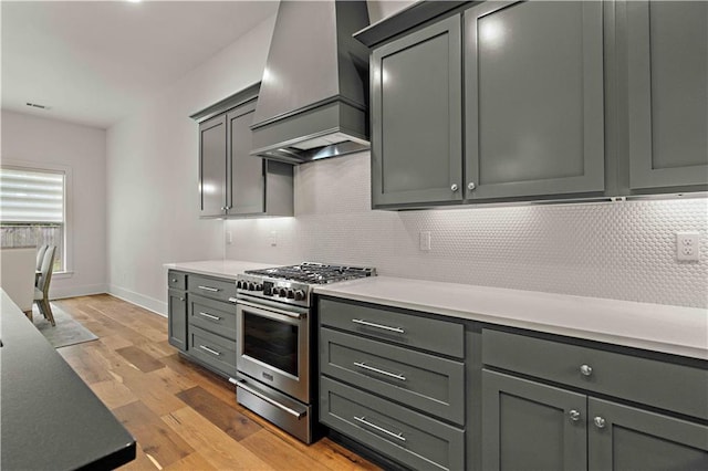 4028 Cypress Point Dr, Covington, LA 70433 - kitchen with high end range, custom range hood, tasteful backsplash, light wood-type flooring, and light countertops