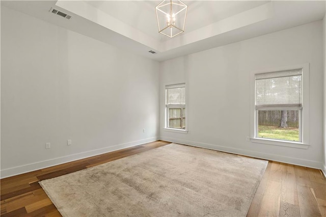 4028 Cypress Point Dr, Covington, LA 70433 - spare room with a raised ceiling, a chandelier, plenty of natural light, and wood finished floors