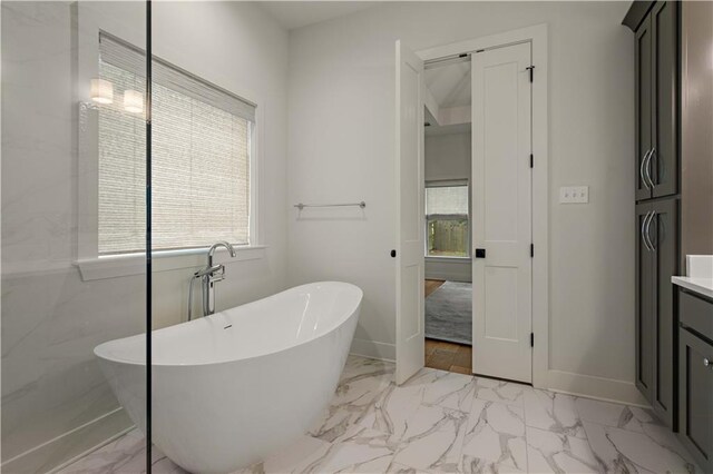 4028 Cypress Point Dr, Covington, LA 70433 - bathroom featuring marble look tile flooring, plenty of natural light, a freestanding tub, and vanity