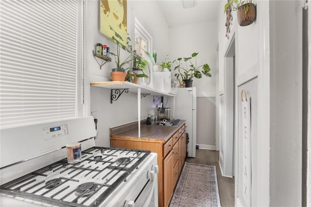 4149-51 Canal St, New Orleans, LA 70119 - kitchen featuring white appliances, brown cabinetry, open shelves, and wood finished floors