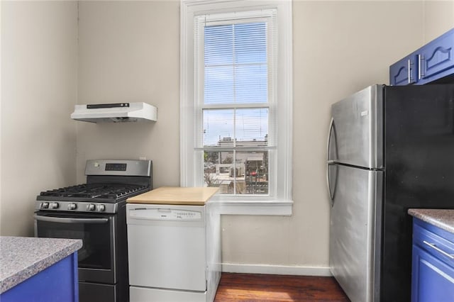 4149-51 Canal St, New Orleans, LA 70119 - kitchen featuring appliances with stainless steel finishes, blue cabinets, under cabinet range hood, dark wood-style floors, and healthy amount of natural light