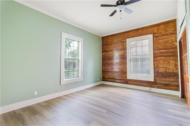 2970 College St, Slidell, LA 70458 - empty room with a ceiling fan, ornamental molding, wooden walls, and light wood-type flooring