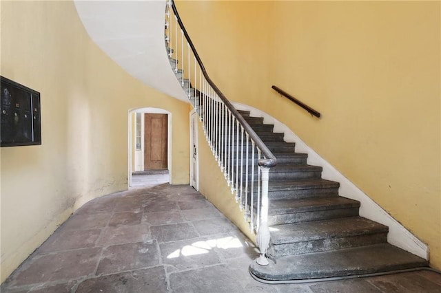 1303 Burgundy St Unit 14, New Orleans, LA 70116 - stairs with stone finish floors, arched walkways, and a high ceiling
