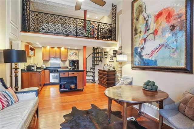740 Esplanade Ave Unit 3, New Orleans, LA 70116 - living room with light wood-style floors, a high ceiling, stairs, and ceiling fan