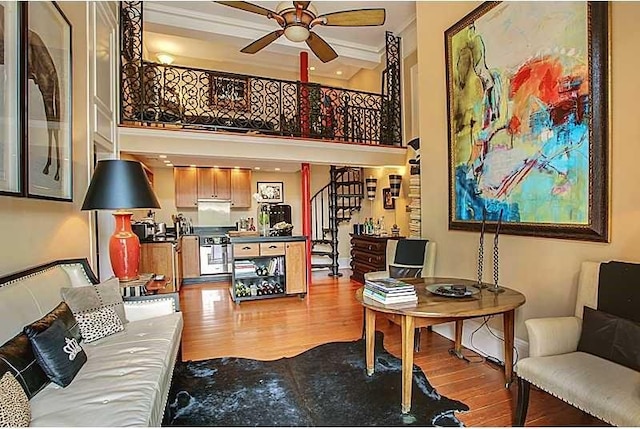 740 Esplanade Ave Unit 3, New Orleans, LA 70116 - living area featuring ceiling fan, wood finished floors, a towering ceiling, ornamental molding, and stairs