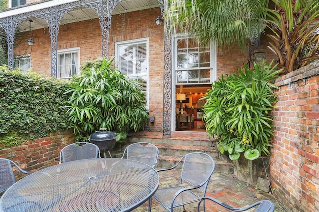 740 Esplanade Ave Unit 3, New Orleans, LA 70116 - view of exterior entry with outdoor dining space and brick siding