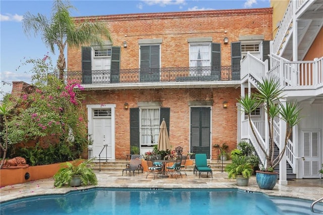 740 Esplanade Ave Unit 3, New Orleans, LA 70116 - back of property featuring brick siding, an outdoor pool, a patio, and stairway
