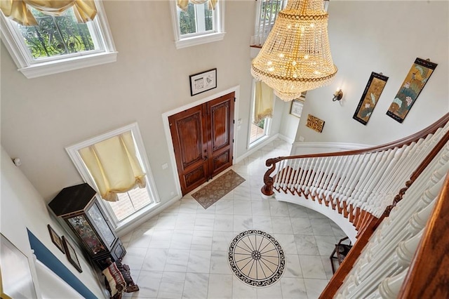 712 Stewart Ave, River Ridge, LA 70123 - foyer entrance with a chandelier, a high ceiling, stairway, and light marble finish flooring