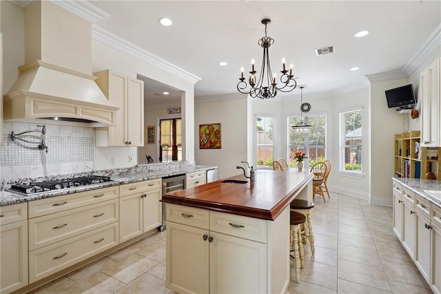 712 Stewart Ave, River Ridge, LA 70123 - kitchen with stainless steel gas stovetop, premium range hood, tasteful backsplash, healthy amount of natural light, and recessed lighting