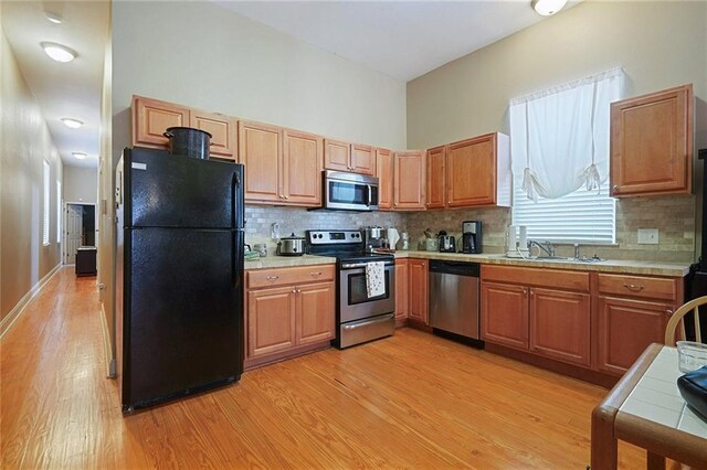 215 N Rendon St, New Orleans, LA 70119 - kitchen with stainless steel appliances, light wood finished floors, and tasteful backsplash