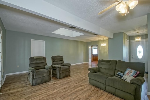 42 Hennessey Ct, River Ridge, LA 70123 - living area featuring a textured ceiling, wood finished floors, a chandelier, a ceiling fan, and a skylight